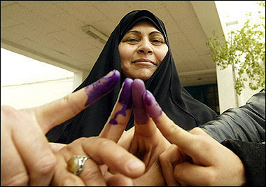 Iraqi women show off their ink stained fingers after voting at a polling station in the Salhiyah district of Baghdad.